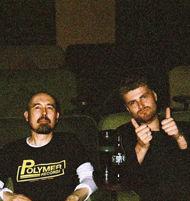 Ibrahim Clayton and Jacob Topen in a cinema, one giving a thumbs up