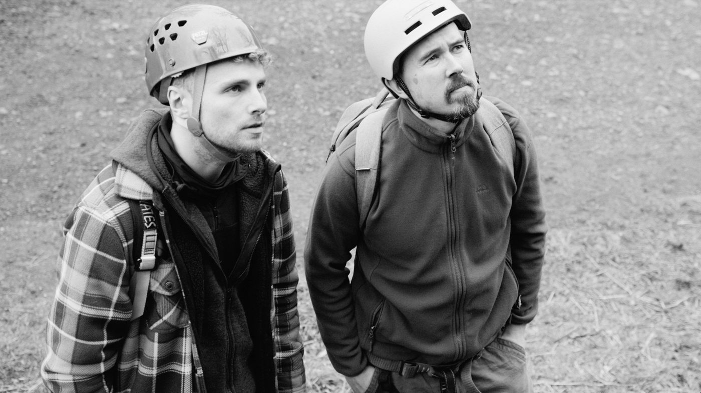 Jacob and Ibrahim in climbing helmets, looking up